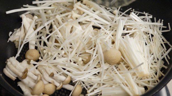 Add the shimeji and enoki mushrooms and continue sauteing.