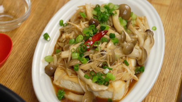 Spoon the mushrooms onto the tofu and pour the sauce over the top. Finally, top with the chopped spring onion leaves.