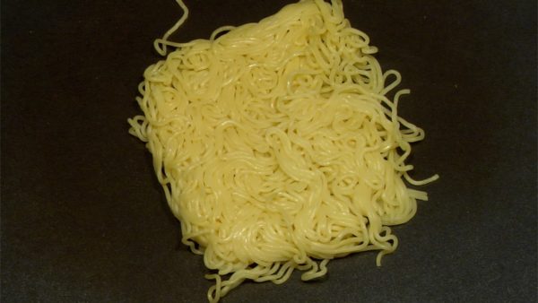 Riscaldate la piastra a circa 240°. Friggete gli spaghetti di yakisoba e versatevi sopra il sake. Premete gli spaghetti con una spatola.