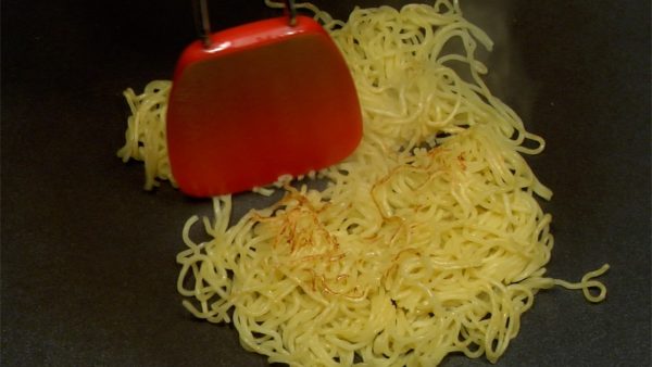 When the other side of the noodles become golden brown, flip it over. Divide the noodles into four sections and slide them to the edge of the griddle.