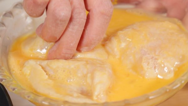 Dip the chicken into the beaten egg. Coat the pieces with the egg evenly.