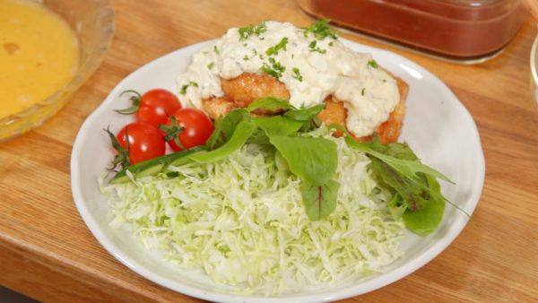 Place the chicken onto a plate along with the side vegetables. Spoon a generous amount of the tartar sauce onto the chicken. Then, top with the shredded parsley leaves.
