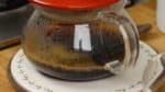 Weiter Wasser über das Kaffeepulver tropfen, bis etwa 250 ml oder eine Tasse Kaffee durchgelaufen sind. Den Filter entfernen, sodass die letzten paar Tropfen nicht mit hineinkommen, weil sie bitter schmecken können.