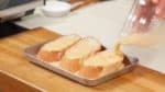 Place 2.5cm (1”) thick slices of baguette in a tray and pour the custard mixture over them. Make sure both sides are completely soaked with the custard mixture. Let the bread sit for 3 to 5 minutes.