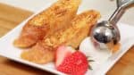 When both sides are golden brown, arrange the French toast onto a plate. The strawberry looks great as a garnish but orange or kiwi fruit can also be used.Spoon the ice cream next to the french toast.