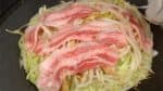 Krydda fläsket med salt och peppar. Rör om den kvarvarande smeten och häll den ovanpå okonomiyakin. Det kommer hjälpa grönsakerna förenas och förhindrar också fläsket att bli segt.