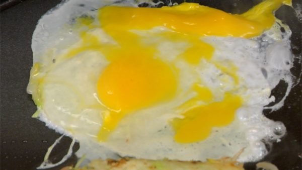 Bersihkan permukaan panggangan dengan handuk dapur yang lembap lalu oleskan minyak sayur kembali. Tambahkan telur, pecahkan kuning telurnya dan bentuk menjadi lingkaran.