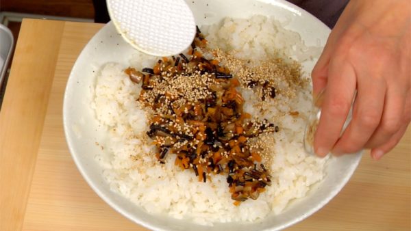 While it is still warm, add the carrot, hijiki seaweed, shiitake mushrooms and toasted sesame seeds to the sushi rice. Mix the sushi rice with the paddle in a slashing motion.