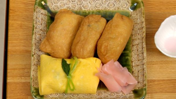 Phục vụ Inarizushi và cơm cuộn (sushi) Fukusa trên đĩa. Cuối cùng, trang trí bằng gừng ngâm.