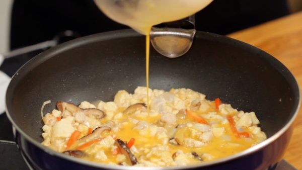 Thoroughly stir-fry the ingredients and reduce the excess broth. Then, pour the beaten egg over the mixture.