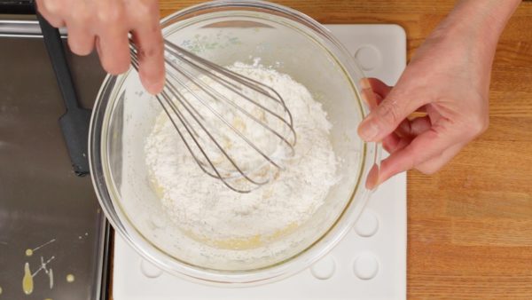 Ajoutez la levure chimique à la farine à gâteau (T45) et mélangez. Ensuite, tamisez la farine dans un bol. Ajoutez la farine au mélange d’œuf. Mélangez petit à petit du centre vers les bords. Cela va éviter les grumeaux de farine. 