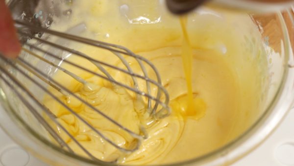 Thêm bơ đã chảy ấm vào hỗn hợp từng chút một. Tránh dùng bơ nóng nếu không sẽ kích hoạt bột nở.