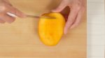 Slice off the mango along the flat seed and make cuts in the flesh in a grid pattern. Be sure not to cut the skin. By the way, this mango is from Miyazaki Prefecture. It is sweet and juicy but also expensive so we only used it for the topping.