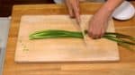 Remove the root ends of the garlic chives. Cut the chives in half and chop them into half inch pieces.