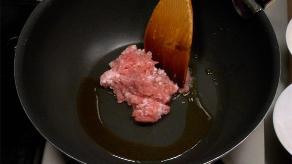 Machen wir Mapo-Tofu. Die Pfanne aufheizen und das Sesamöl hineingeben. Das Öl in der Pfanne verteilen. Das Schweinehackfleisch auf hoher Hitze braten und dabei zerkleinern.