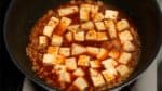 豆腐も加えてつぶさないようにそっと広げます。沸騰するまで強火、沸騰したら中火の弱にして２～３分煮こみます。この間に豆腐の水分は程よく抜け、中に味がしみ込みます。