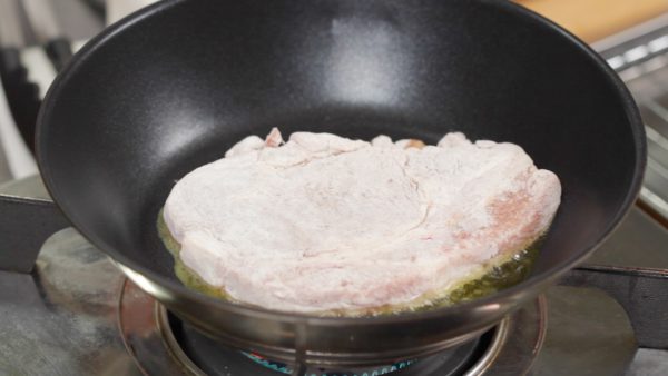 Heat a pan on medium heat and add a generous amount of vegetable oil. Place the pork loin steak onto the heated pan. Make sure to cook the top side first so that you can present a beautifully browned surface. Occasionally swirl the pan to help brown the surface evenly.