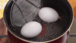 Chúng tôi sẽ làm trứng luộc chín một nửa. Giảm lửa xuống mức thấp và để cẩn thận 2 quả trứng vào nồi nước sôi. Trong 2 phút đầu tiên, xoay nhẹ trứng để giúp lòng đỏ trứng luôn nằm ở trung tâm. Luộc trứng tổng cộng trong khoảng năm và nửa phút.