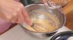 For the batter, combine another beaten egg and the flour in a bowl. Stir to mix. Add a small amount of water until the batter has the desired consistency like shown.