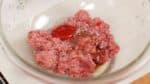 Để hỗn hợp thịt bò và lợn xay trong bát và rắc muối và tiêu đen nghiền thô lên. Thêm sốt Worcester kiểu Nhật hay sốt Worcester thường và tương cà chua (ketchup).
