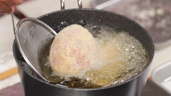 Faites frire les scotch eggs. Faites chauffer l'huile à 170°C (338°F) dans une casserole. Ajustez la forme et placez chaque scotch egg dans l'huile.