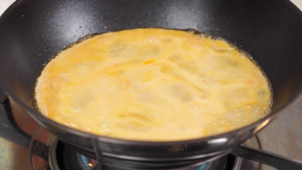 Lightly stir the egg mixture and quickly pour it into the pan.