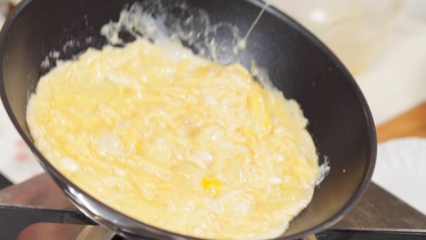 When the edges begin to firm up, keep moving them to the center of the pan to give the egg an even silky texture. Keep watching the consistency of the egg and remove the pan from the burner to adjust the heat. Cook the egg halfway through and now it is ready.