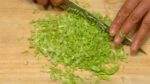 Vamos preparar os ingredientes para gyoza. Corte as folhas do repolho em tiras. Pique-os em pedaços de 2~3mm (1/8").
