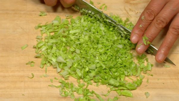 Let's prepare the ingredients for gyoza. Cut the cabbage leaf into strips. Chop them into 2~3mm (1/8") pieces.