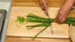 先把韭菜根莖切碎，然後再把韭菜葉一刀切成兩半，再切成小片。把蒜和姜磨成蒜泥和薑蓉。
