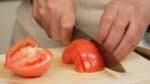 Chúng tôi sẽ chuẩn bị rau củ. Cắt cà chua làm đôi và loại bỏ phần thân còn lại của cà chua. Thái nó thành các lát 5 mm (0,2 inch)