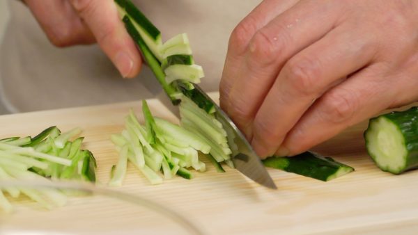 Épluchez les peaux épaisses du concombre, ça fait un motif zébré. Coupez le concombre en 4 morceaux égaux. Ensuite, coupez les morceaux en aiguilles. 