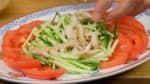 Arrangez les tranches de tomates sur les bords de l'assiette. Couvrez le centre avec le concombre. Ajoutez la peau du poulet.