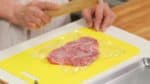 Cover the sirloin or rump steak with plastic wrap. And pound the meat with a rolling pin until the thickness reaches about 8mm (0.3”).