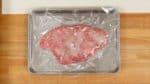 Cover the tray with plastic wrap and let it sit in a relatively cool place for 30 minutes to 1 hour. Placing it in the refrigerator will make the enzymes work slower so it will need to sit longer. In this case, remove the meat at lease 30 minutes before cooking to bring it to room temperature.