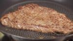 This steak is relatively thin so flip it over when the other side is golden brown. Shake the pan or gently press the meat with tongs to help it brown evenly.