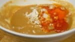 Wenn die Suppenbasis gut vermengt ist, fügt die gehackte Frühlingszwiebel und das scharfe Chili Öl hinzu. 