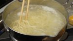 Nun lasst uns das Tantanmen anrichten. Kocht als erstes die frischen Ramennudeln in dem Topf mit dem noch heißen Wasser und lockert sie mit Kochstäbchen auf. 