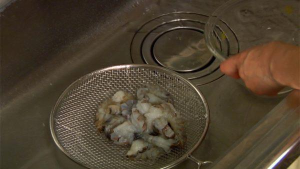 Take the bowl to the sink. Rinse the prawns in the bowl under running water, discarding the water several times until it is clear. Place the prawns on a mesh strainer and drain well.