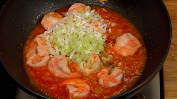 Drop in the prawns and chopped long green onion.