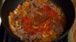 アルコールの匂いがしなくなったら残りのスープ、トマト水煮、はちみつ、ローリエを加えます。火を強くして軽くお玉で混ぜます。