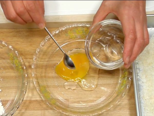 Crack the egg into a bowl and spoon a quarter of it into a shallow dish. Add a sprinkle of water and beat well with a whisk.