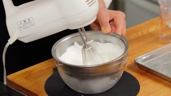 大福に入れるホイップクリームを用意します。ボウルは氷で冷やしてください。砂糖を加えハンドミキサーで泡だてます。かたくホイップできたら生クリームを綺麗に落とします。絞り出し袋に入れます。少し絞って中の空気を除きます。
