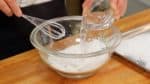 Let's make the mochi. Combine the mochiko, sweet rice flour and granulated sugar in a microwave-safe bowl. Add the water and thoroughly mix.