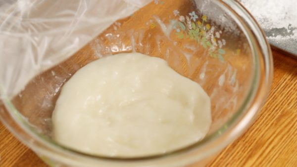 Tutup kembali mangkuk dengan plastik wrap. Microwave adonan mochi selama 1 menit. Setelah adonan mochi mulai bening atau transparan, hentikan memanaskannya. Adonan mochi dipanaskan dalam 2 tahap untuk menghindari overcooking (terlalu matang).