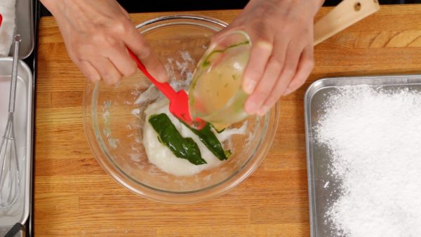 Mouillez à nouveau l'intérieur du bol et pétrissez bien le mochi. Ajoutez la poudre de thé vert matcha diluée et mélangez. Diluer la poudre avant va aider à la mélanger avec le mochi. 