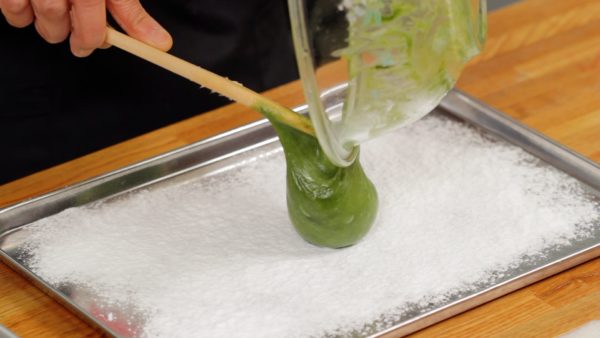 Quand le matcha est bien mélangé, transférez le mochi sur le plateau couvert de fécule de pomme de terre. 