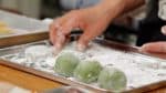 Tightly close the edges of the mochi. Repeat the process to wrap the rest of the anko balls.