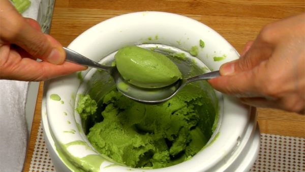 Scoop the green tea ice cream with a spoon. Use another spoon to shape and make two balls. Serve the ice cream and add the brown rice flakes.
