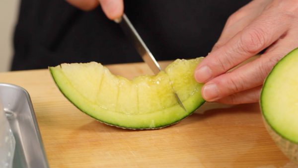 Let’s make the fresh melon sauce with the rest of the melon. Slice off a wedge. Remove the skin and cut the flesh into 2cm (0.8") pieces.